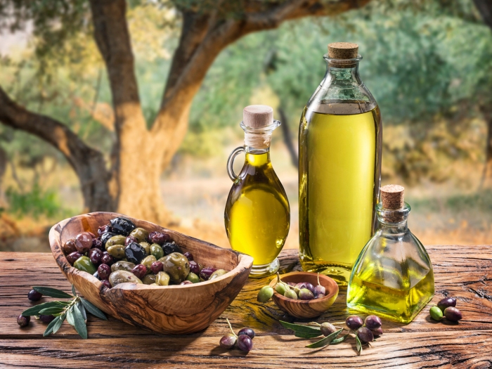 Olives and olive oil on the nature background.